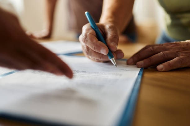 Close up of unrecognizable person signing a contract in the office. hand signing paper
